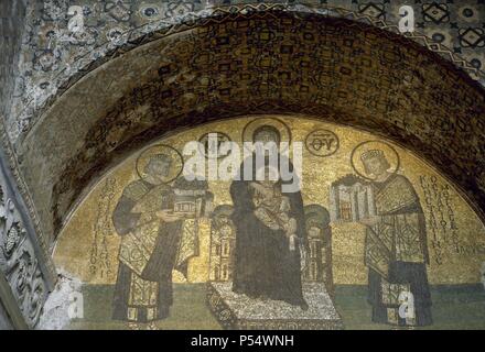 ARTE BIZANTINO. TURQUIA. Representación de LA VIRGEN MARIA SENTADA EN UN TRONO EN ACTITUD HIERATICA, CON EL NIÑO JESUS SOBRE SUS RODILLAS. A LA IZQUIERDA EL EMPERADOR JUSTINIANO, OFRECIENDO SIMBOLICAMENTE LA BASILICA DE SANTA SOFIA. A LA DERECHA, HACIENDO LO PROPIO CON CONSTATINOPLA, EL EMPERADOR CONSTANTINO. Mosaico del tímpano de La Puerta del nártex (finales siglo X). ESTAMBUL. Stockfoto