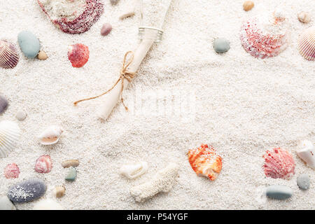 Bunte Muscheln und Meer Kiesel auf weißem Strand Sand & Flasche mit einer Nachricht. Sommer Urlaub Konzept. Kopieren raum Hintergrund. Stockfoto