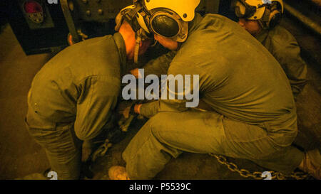 Pazifik - Marines mit Combat Logistik Bataillon 15, die Logistik Combat Element des 15 Marine Expeditionary Unit, Kette 7-Tonnen-LKW auf dem Boden der gut-deck an Bord der USS Pearl Harbor (LSD 52) während Composite Trainingsgerät Übung, 9. Mai 2017. Die Bekämpfung der Cargo Abteilung ist für die Organisation und die Bewegung der Marines, Fahrzeuge und Ausrüstung an Bord des Schiffes verantwortlich. COMPTUEX bereitet die MEU effektiv Marines bewegen und Ausrüstung von Sea-zu-Ufer, und in strengen Umgebungen betreiben. Stockfoto