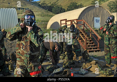 HUNTER LIGGETT, Calif. (10. Mai 2017) - seabees zu Naval Mobile Konstruktion Bataillon (NMCB) 4 zugeordneten Don ihre Mission Oriented schützende Haltung (MOPP) Gang während eines simulierten chemischen, biologischen und radiologischen (CBR) Angriff auf Fort Hunter Liggett, Calif., 10. Mai als Teil der Bataillone' Feld. Die Ausbildung ist so konzipiert, dass alle Aspekte der Defensive und operativen Fähigkeiten des Bataillon von Manning eine kämpfende Position in der Gesellschaft zu reagieren auf chemische Kriegsführung Bedrohungen für Übung und Improvised Explosive Devices. Stockfoto