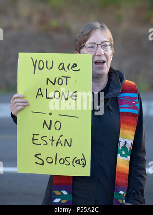 Seatac, Washington, USA. 24 Juni, 2018. Pfr. Patricia Simpson hält ein Zeichen, wie Sie entlang der Zaun der Federal Detention Center in Seatac, Washington betet, Anfang Juni 24 während einer Gebetsvigil in Unterstützung der Zugewanderten Eltern im Gefängnis, die von ihren Kindern getrennt wurden. Simpson ist ein Pastor der Evangelisch-methodistischen Kirche. Credit: Paul Jeffrey/Alamy leben Nachrichten Stockfoto