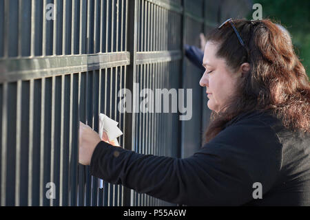 Seatac, Washington, USA. 24 Juni, 2018. Eine Frau betet am Zaun entlang, die das Federal Detention Center in Seatac, Washington, Anfang Juni 24 während einer Gebetsvigil in Unterstützung der Zugewanderten Eltern im Gefängnis, die von ihren Kindern getrennt wurden. Die mahnwache wurde durch die Vereinigte Methodistische Kirche gefördert. Credit: Paul Jeffrey/Alamy leben Nachrichten Stockfoto