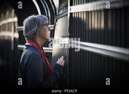 Seatac, Washington, USA. 24 Juni, 2018. Pfr. Maria Kohlstaedt Huycke betet am Zaun der Federal Detention Center in Seatac, Washington, Anfang Juni 24 während einer Gebetsvigil in Unterstützung der Zugewanderten Eltern im Gefängnis, die von ihren Kindern getrennt wurden. Huycke ist Pastor der Vereinigten Methodistischen Kirche. Credit: Paul Jeffrey/Alamy leben Nachrichten Stockfoto