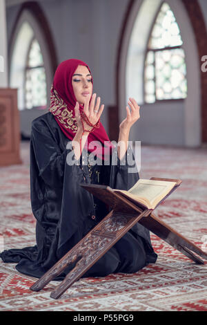 Junge muslimische Frau zu beten mit dem Rosenkranz in der Moschee Stockfoto