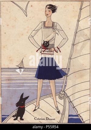 Frau stehend auf Yacht tragen 1930 sailor Mode, eine Marine blauen Rock, weiße Bluse mit einem Design von einer Katze den Kopf. Schwarzer Hund im Vordergrund. Papierkörbe pochoir (Schablone) Lithographie von der Französischen luxus Mode Magazin "Kunst, Gicht, Beaute' 1930. Stockfoto