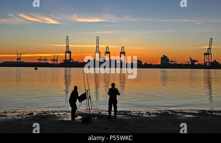 Angler fischen auf neue Brighton Beach auf dem Wirral, Merseyside, wie die Sonne über dem Hafen von Liverpool und den Fluss Mersey. Stockfoto