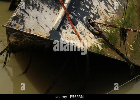 Küstenlandschaften - Verfall - einem Gekenterten Boot Wrack auf der linken Seite auf der Website von seiner letzten Verankerung liegt. Essex, Großbritannien Stockfoto