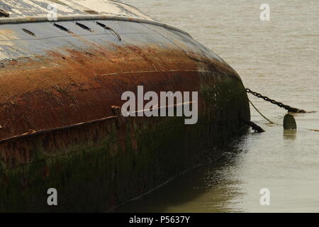 Küstenlandschaften - Verfall - einem Gekenterten Boot Wrack auf der linken Seite auf der Website von seiner letzten Verankerung liegt. Essex, Großbritannien Stockfoto