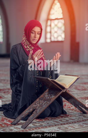 Junge muslimische Frau zu beten mit dem Rosenkranz in der Moschee Stockfoto