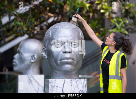 Friederike Huber reinigt Aluminium Köpfe von "Numen (Verschiebung Votive)" durch Thomas J Preis gegossen, vor der Öffnung der Skulptur in der Stadt, eine jährliche Veranstaltung, die Kunst im öffentlichen Raum verfügt über 18 Kunstwerke von international bekannten Künstlern unter architektonische Sehenswürdigkeiten in London's Square Mile. Stockfoto