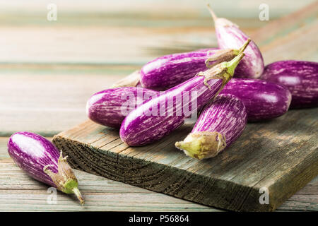Haufen kleine Aubergine oder Aubergine Gemüse auf alten hölzernen Hintergrund. Gesunde Ernährung Konzept mit kopieren. Stockfoto