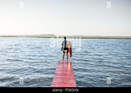 Mann mit paddleboard in der Nähe des Sees Stockfoto