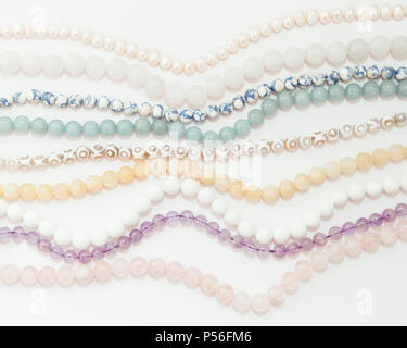 Einstellen der Threads, die verschiedenen Halbedelsteinen Perlen in hellen Pastelltönen, rosa Quarz, weißer Achat, Perlen, Jade, violett Amethyst, Greenstone und turquo Stockfoto