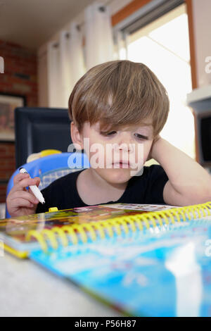 Montreal, Kanada, 24. Juni 2018. Junge 3 Jahre alten Jungen lernen, wie zu lesen. Credit: Mario Beauregard/Alamy leben Nachrichten Stockfoto