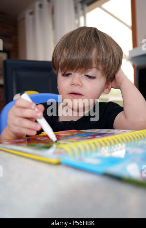 Montreal, Kanada, 24. Juni 2018. Junge 3 Jahre alten Jungen lernen, wie zu lesen. Credit: Mario Beauregard/Alamy leben Nachrichten Stockfoto