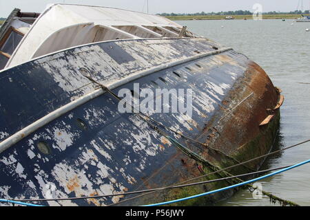 Küstenlandschaften - Verfall - einem Gekenterten Boot Wrack auf der linken Seite auf der Website von seiner letzten Verankerung liegt. Essex, Großbritannien Stockfoto