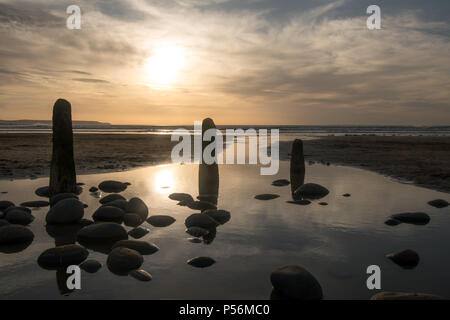 Buhnen und Steinchen auf Westward Ho! Gegen den Sonnenuntergang Silhouette Stockfoto