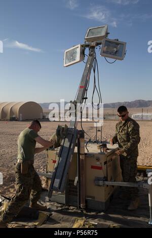 Staff Sgt. Lucas Weiß, ein Ingenieur Systeme Elektrik Techniker mit Wartung Unternehmen, Bekämpfung Logistik Bataillons 451, Bekämpfung der Logistik Regiment 45, 4 Marine Logistik Gruppe, und Lance Cpl. Eli Sommers, eine Kälte- und Klimatechnik Techniker mit Dienstprogrammen, CLR45, 4. MLG, heben ein scheinwerferlicht während integrierte Ausbildung Übung 4-18 bei Marine Corps Air Ground Combat Center Twentynine Palms, Kalifornien, Juni 12, 2018, 12. Juni 2018. Marines mit der Ausübung Support Element von ITX 4-18 bereitgestellten Service beim Essen, An- und Abreise Verarbeitung, bulk Kraftstoff, camp Engineering Stockfoto