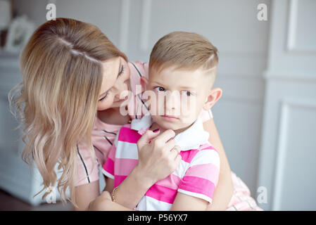 Mutter umarmt ihren kleinen Jungen, während er umgekippt. Stockfoto