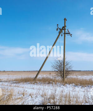 Ein einsamer Gebrauchspfosten im Feld, die Polen mit baumelnden Kabel Stockfoto