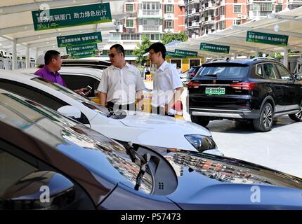 (180625) - Peking, 25. Juni 2018 (Xinhua) - die Menschen warten auf ihre elektrischen Autos in Xiamen aufgeladen haben, im Südosten der chinesischen Provinz Fujian, 25. Mai 2018. Für die meisten Chinesen in den 70er Jahren, einer Ihrer Träume war zu eigenen "Drei Dinge mit Rädern und ein vocal Sache', d. h., ein Fahrrad, eine Nähmaschine, eine Uhr und ein Radio. Im Großen und Ganzen ist dieser Traum wurde leicht zugänglich während der 1980er und 1990er Jahren und die "grossen Vier" von Fernseher, Kühlschrank, Waschmaschine und Tonbandgerät. Mit der Menschen ständig wachsende Bedürfnisse für ein besseres Leben zusammen mit raschen wirtschaftlichen und Technolog Stockfoto