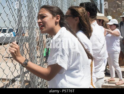 Tornillo, Texas, USA. 24. Juni, 2018. ALEXANDRIA OCASIO - CORTEZ, ein kongreßanwärter vom New York 14, stand zitternd den Zaun mit anderen Demonstranten riefen in Richtung Bundesimmigrationmittel mit Fragen zur Trennung von Kindern zu stoppen und die Kinder in die Zelte in der Nähe der Mautstelle Tornillo-Guadalupe untergebracht. Hunderte von Menschen an der Tornillo, TX, Hafen von Eintrag versammelt der Trumpf Verwaltungen null Toleranz Politik in Bezug auf die Einwanderung und die Trennung der Kinder von ihren Eltern zu protestieren, wenn sie angehalten werden, während die Einreise in die Vereinigten Staaten. (Bild: Stockfoto
