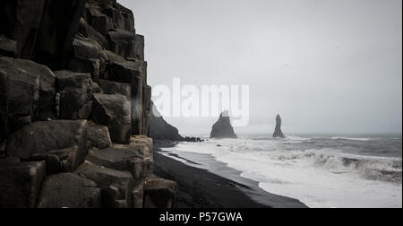 Basaltsäulen und Klippen, schwarzer Sand Strand, schlechtes Wetter, Strand Reynisfjara, South Island, Island Stockfoto