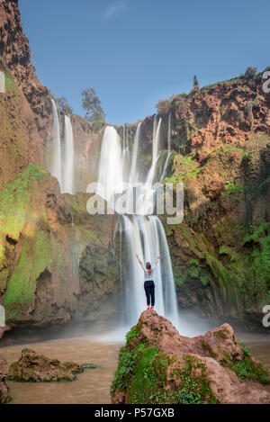 Junge Frau stehen auf einem Stein vor ouzoud Wasserfälle und Kaskaden, Cascades d'Ouzoud, Fluss Oued Tissakht, Mittlerer Atlas Stockfoto