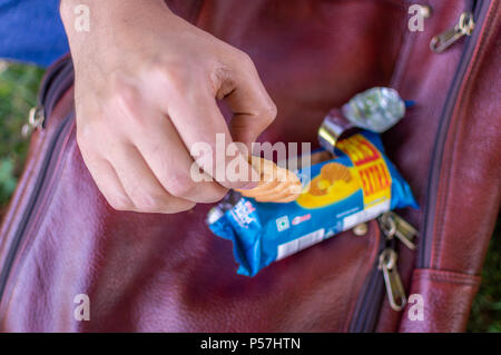 Srinagar, Jammu und Kaschmir, Indien: vom: 1. Juni 2018 - eine Person, die ein Cookie von einer Abdeckung auf seinem Beutel gehalten Stockfoto