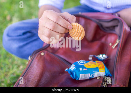 Srinagar, Jammu und Kaschmir, Indien: vom: 1. Juni 2018 - eine Person über ein Cookie, das er nur aus dem Paket nahm zu essen. Stockfoto