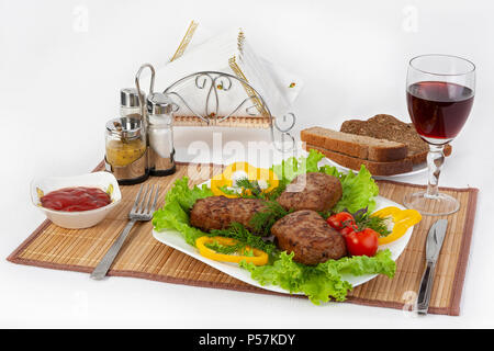 Koteletts mit grünen, Tomaten und Gurken. Mit schwarzen oder weißen Brot und einem Glas Rotwein servieren. Eine perfekte Ergänzung ist eine heiße Soße und Senf. T Stockfoto