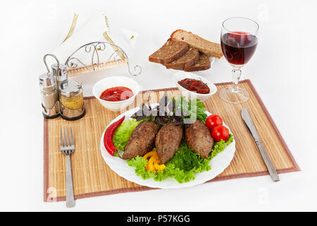 Koteletts mit grünen, Tomaten und Gurken. Mit schwarzen oder weißen Brot und einem Glas Rotwein servieren. Eine perfekte Ergänzung ist eine heiße Soße und Senf. T Stockfoto