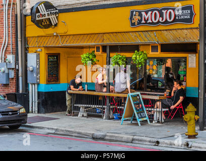 ASHEVILLE, NC, USA-24. Juni 18: Der Mojo Küche & Lounge, eine farbenfrohe Einrichtung auf College Street. Vier junge Leute sprechen, betrachten Ihre pho Stockfoto