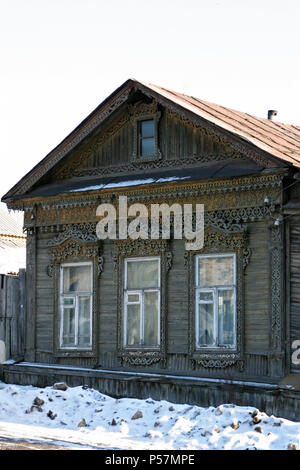 Altes Russisches Haus mit geschnitzten Fensterrahmen. Schöne Holzhaus im Winter Wetter. Stockfoto