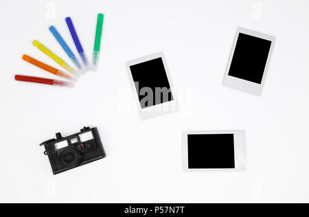 Drei leere Instant Fotos Frames auf weißem Hintergrund mit einem Mini Kamera und bunten Markierungen isoliert Stockfoto