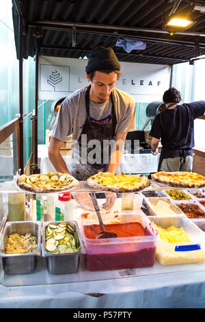 Mann, der Pizza an einer Garküche in Greenwich, London, UK (kleine Blätter Essen) Stockfoto