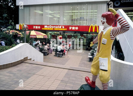 Ronald McDonald, die ikonische rothaarigen Clown, dass ist der berühmte Werbung Symbol für einen weltweiten Fast-Food-Kette, begrüßt die hungernden Völker zu einem McDonald's Restaurant in Singapur in Südostasien. Es ist eines von sieben Standorten der Hamburger Kette entlang der eleganten Einkaufsstraße Orchard Road. Ronald wurde als Maskottchen der amerikanischen Firma im Jahr 1963 eingeführt und Jetzt lächelt Diners, die an mehr als 35.000 McDonald's Restaurants in über 100 Ländern. Stockfoto