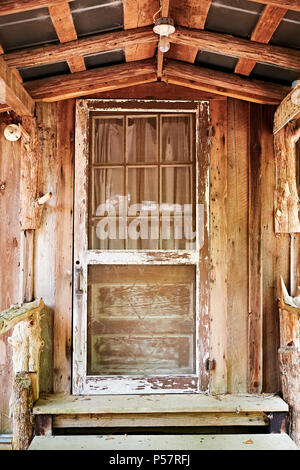 Alte antike Holz--Tür in eine alte Hütte mit überdachter Veranda im ländlichen Alabama, USA. Stockfoto