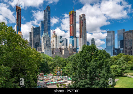 New York, USA, 25. Juni 2018. Die neue schlanke skyscapers in Midtown New York errichtet werden, ändern die Skyline der Stadt. Ein kleiner Vergnügungspark in Cen Stockfoto