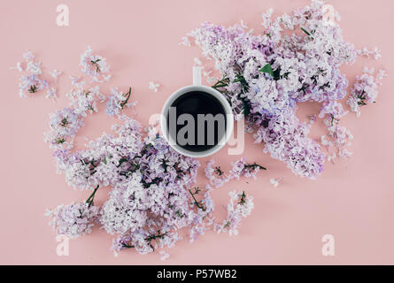 Ansicht von oben Feder minimalen Begriff. Flach Zweige der lila Blüten mit Tasse Kaffee auf rosa Hintergrund Stockfoto