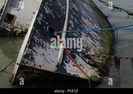 Küstenlandschaften - Verfall - einem Gekenterten Boot Wrack auf der linken Seite auf der Website von seiner letzten Verankerung liegt. Essex, Großbritannien Stockfoto