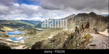 Schmale Riff mit Klettern Kabel auf dem Wanderweg zu Mussala Gipfel und den Blick auf die fernen Rila-seen von oben Stockfoto