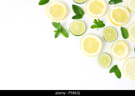 Styled Foto. Sommer Kräuter und Obst Zusammensetzung. Kalk, Zitronenscheiben und frische grüne Minze auf weißem Hintergrund. Saftige essen Muster. Dekorative Ecke. Flach, Ansicht von oben. Stockfoto