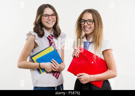 Happy High School Freunde Closeup Portrait. Vor der Kamera posieren, in Schuluniform, Bücher und Hefte, auf einem weißen Hintergrund. Stockfoto