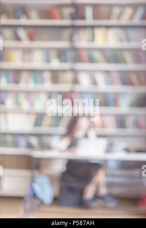 Abstrakte verschwommen unkenntlich Mädchen lesen Laptop in der öffentlichen Bibliothek, Hochschrank, Bücherregal, viele Bücher, vertikale Hintergrund. Konzept der Studing, Bildung Stockfoto