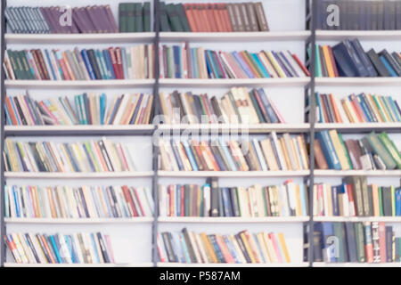 Abstrakte verschwommenen Hintergrund der Bücherregale mit Büchern in öffentlichen Bibliotheken, Buchhandel, zu Hause, modernen hellen Hintergrund. Konzept des Lernens, zurück zur Schule, Bildung Stockfoto