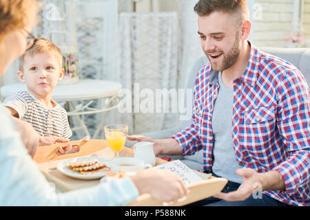 Portrait von Frau und Sohn überraschend jungen Mann mit Frühstück und hausgemachten Plätzchen für Vatertag, auf den Vater Fokus Stockfoto