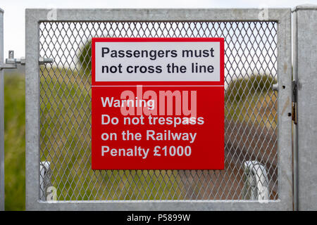 Die Passagiere müssen die Linie Bahn Warnzeichen nicht Kreuz Stockfoto