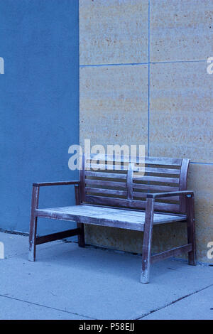 Shabby Chic Bank gegen eine blau und beige moderne Mauer aus Stein auf einer Stadt Bürgersteig set vermittelt ein kühles monochromatischen suchen Stockfoto