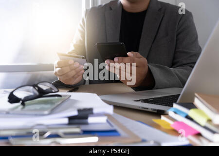 Geschäftsmann mit Phone Smartphone und Notebook Stockfoto